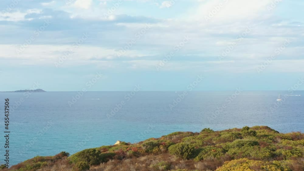 View from above, stunning aerial view of a green coastline bathed by a calm sea. Capo Figari, Sardinia, Italy.