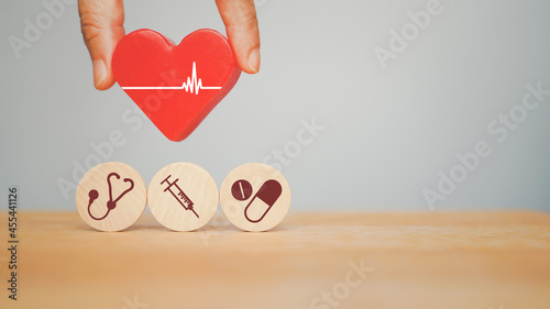 hand holding red heart with heartbeat over health and medical icon sign for health insurance , wellness ,wellbeing concept