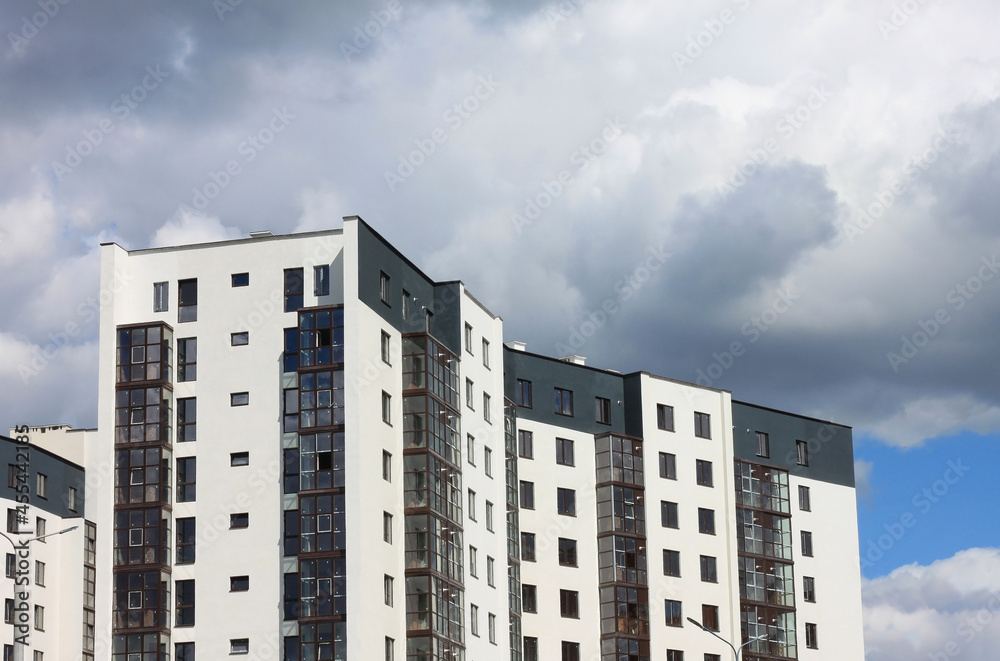 Construction of modern multi-storey building on blue cloudy sky background Construction of modern multi-storey building on blue cloudy sky background