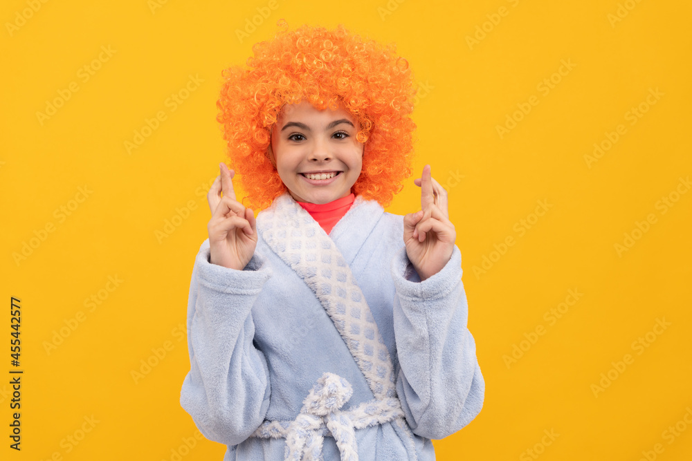 funny kid in curly clown wig. fancy child wear home bathrobe.
