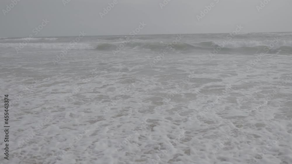 s log footage. white sand beach. waves crashing to the shore. White ocean see water. cloudy climate. nature landscape