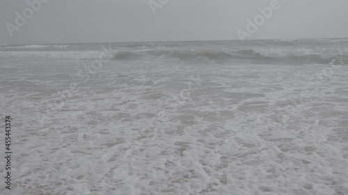 s log footage. white sand beach. waves crashing to the shore. White ocean see water. cloudy climate. nature landscape