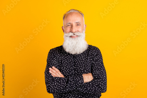 Photo portrait man wearing shirt smiling showing thumb blank spacewith crossed hands isolated vibrant yellow color background photo