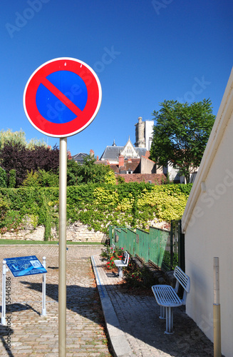 Bright Coloured Road Sign seen against background of Blue Sky & Old Buildings 