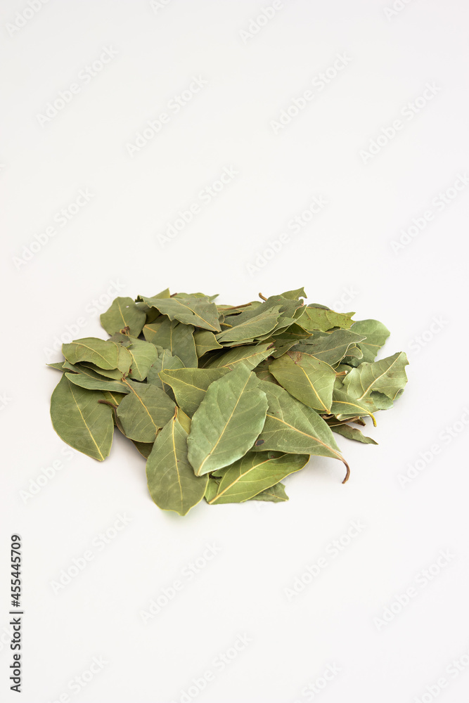 Pile of dried bay leaves isolated on white surface. Close up studio shot, top view, no people
