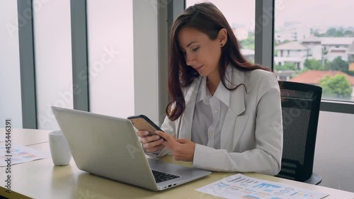 Beautiful woman in formal outfit get relax while working and using smartphone with happy emotion in modern workplace office