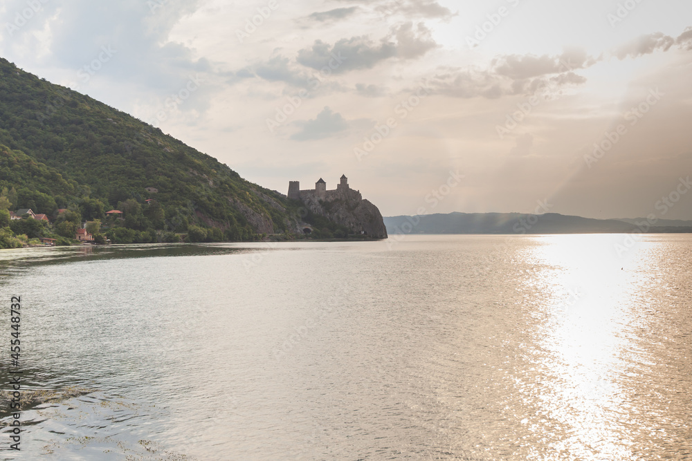 The Golubac Fortress, medieval fortified town, Danube river at sunset. Sun reflection on the water. The Golubac Fortress, medieval fortified town, Danube river at sunset. Sun reflection on the water.