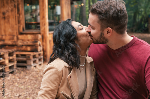 young beautiful and in love - couple kisses in an outdoor cafe restaurant