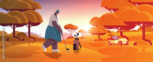senior woman playing golf on green golf course aged african american player taking a shot active old age concept