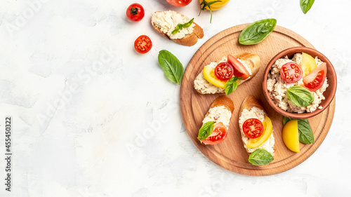 Tasty sandwich with tomatoes, cream cheese and basil leaves on white background. Long banner format. top view
