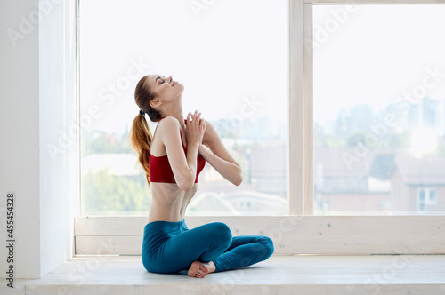 woman doing yoga exercises near the window energy asana