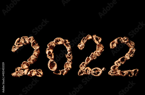 2022 new year. Numbers made from a pile of nutshells. Food style calendar. Wallpaper. Banner. Brown color walnut texture. Signed two and zero. Flat lay mockup design. Business card. Black background