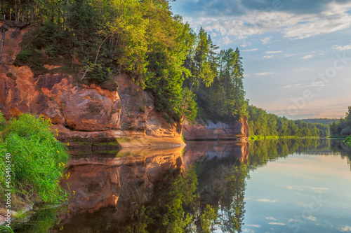 Peaceful landscape with Gauja river and red sandstone Erglu kliffs steep rocks in Gauja National Park in Valmiera area