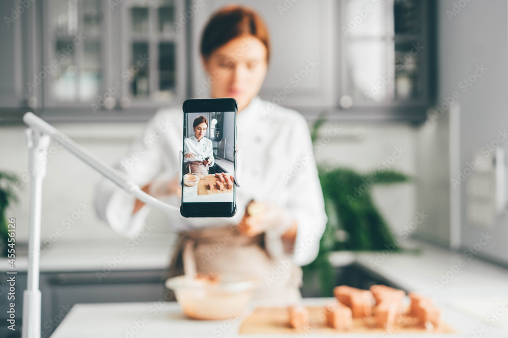 Food blogger showing process of making cakes online.