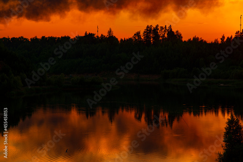 Black smoke against the background of a bright flaming sunset . © FO_DE