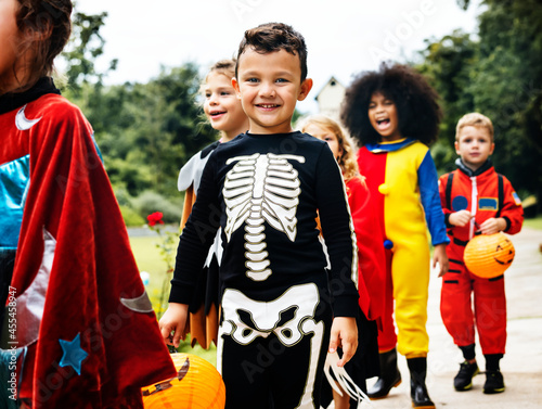 Young kids trick or treating during Halloween Fototapeta