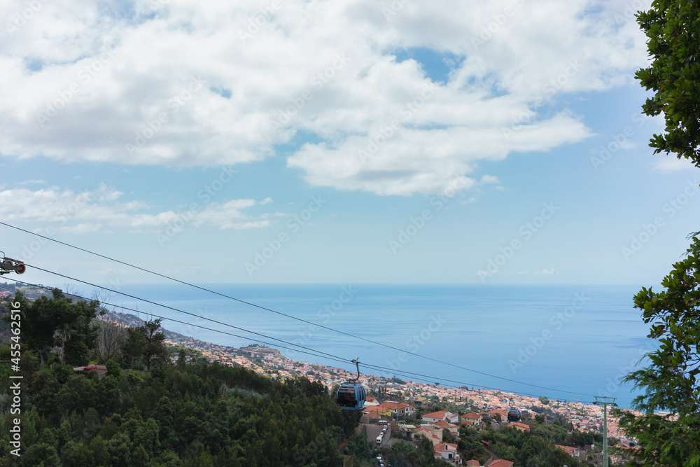 Fototapeta premium Beautiful views of the Atlantic Ocean and a blue sky, taken from the highest point of Funchal, where you can also see the cable car going up.