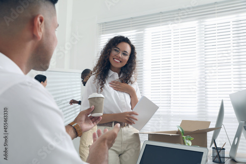 Εκτύπωση καμβά Employee offering cup of coffee to new coworker in office