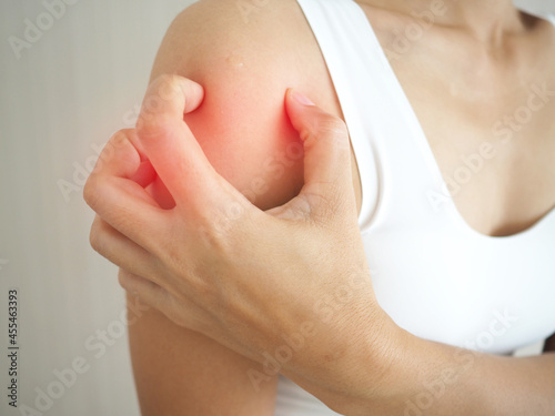 A woman with itching scratching her shoulder skin caused by eczema, allergic skin, dermatitis and insect bites. closeup photo, blurred. photo