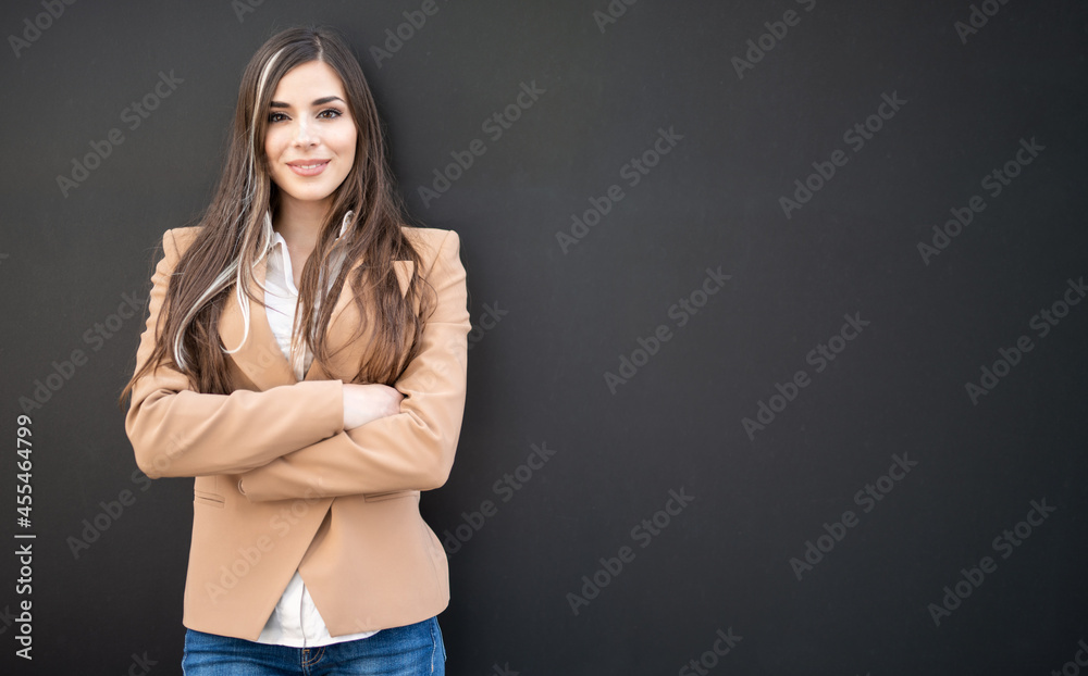 Smiling businesswoman standing against a blackboard Smiling businesswoman standing against a blackboard