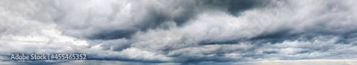 Stormy cloudy sky wide panorama, dramatic dark blue thunderclouds, gale cloudscape, gray cumulus rain clouds panoramic view, thunderstorm heaven landscape, overcast cloudiness weather, hurricane skies