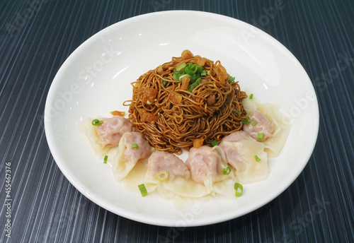 stir fried dry wanton noodle mee with meat dumpling on dark grey wood background dim sum halal menu photo