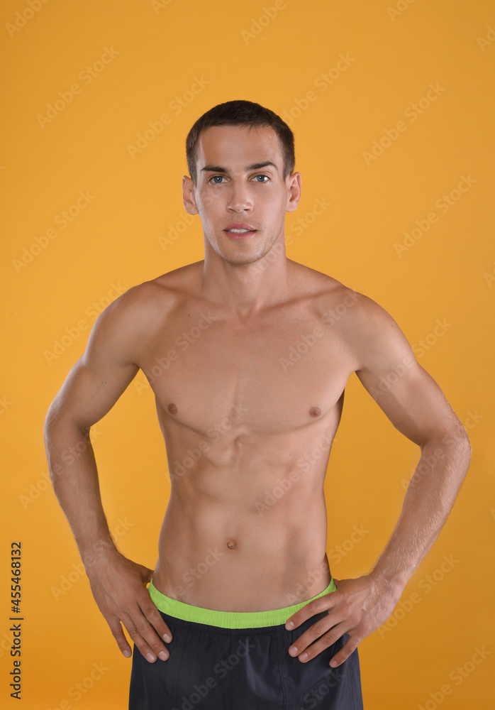 Fototapeta premium Handsome shirtless man with slim body on yellow background
