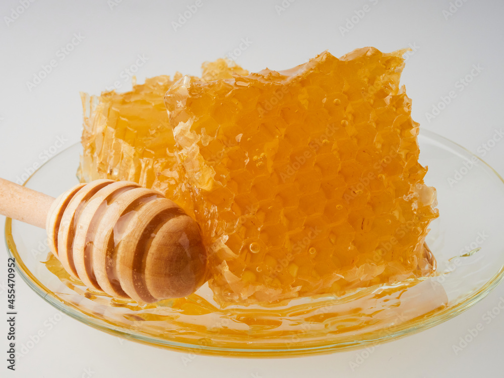 Glass pot of honey, honeycombs and sweet sticky honey puddle isolated on white background. Glass pot of honey, honeycombs and sweet sticky honey puddle isolated on white background.