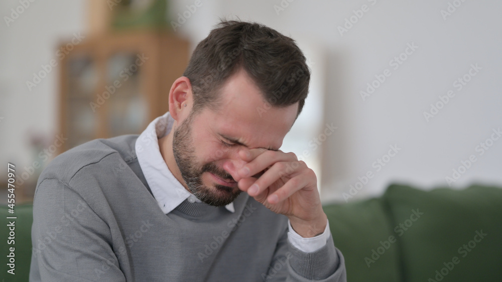 Middle Aged Man Crying While Sitting on Sofa Middle Aged Man Crying While Sitting on Sofa