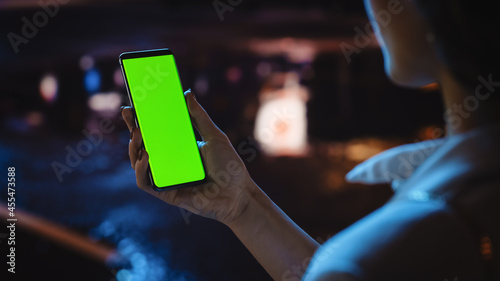 Wallpaper Mural Beautiful Woman using Chroma Key Smartphone while Walking Through Night City Street Full of Neon Light. Female Using Green Screen Mobile Phone. Over the Shoulder Close-up Shot Torontodigital.ca