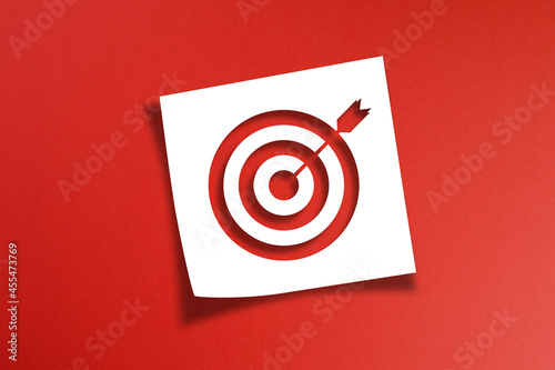 Note paper with target sign on red background 