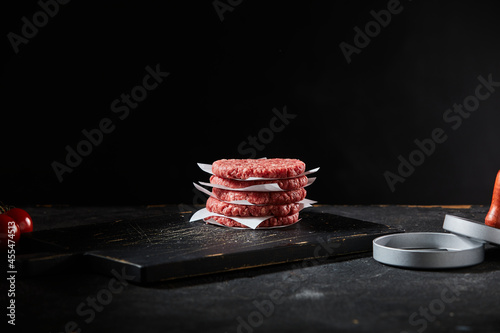 Photography Stacked freshly made beef burger patties with patty former