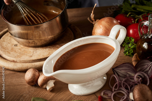 Gravy boat with serving of delicious rich brown sauce or gravy photo