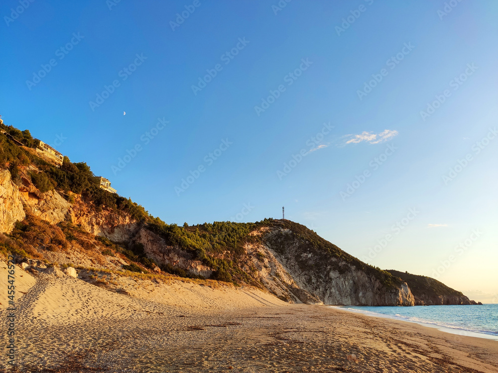 Sunset Mylos sandy beach on coast with high cliffs of Lefkada island in Greece. Summer travel to Ionian Sea Sunset Mylos sandy beach on coast with high cliffs of Lefkada island in Greece. Summer travel to Ionian Sea