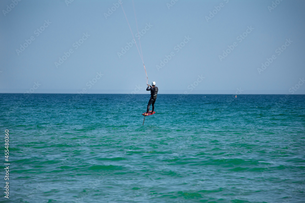 A man practicing Kitesurfing in the ocean A man practicing Kitesurfing in the ocean