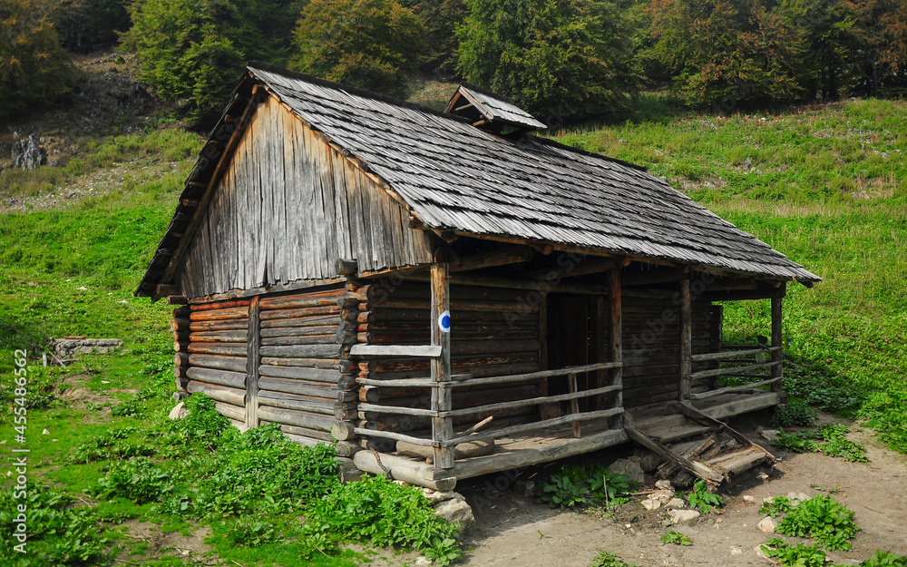 An abandoned, old wooden sheepfold in a beautiful pasture, surrounded by a beech forest. Autumn season. Rustic shelter. Carpathia, Romania. An abandoned, old wooden sheepfold in a beautiful pasture, surrounded by a beech forest. Autumn season. Rustic shelter. Carpathia, Romania.
