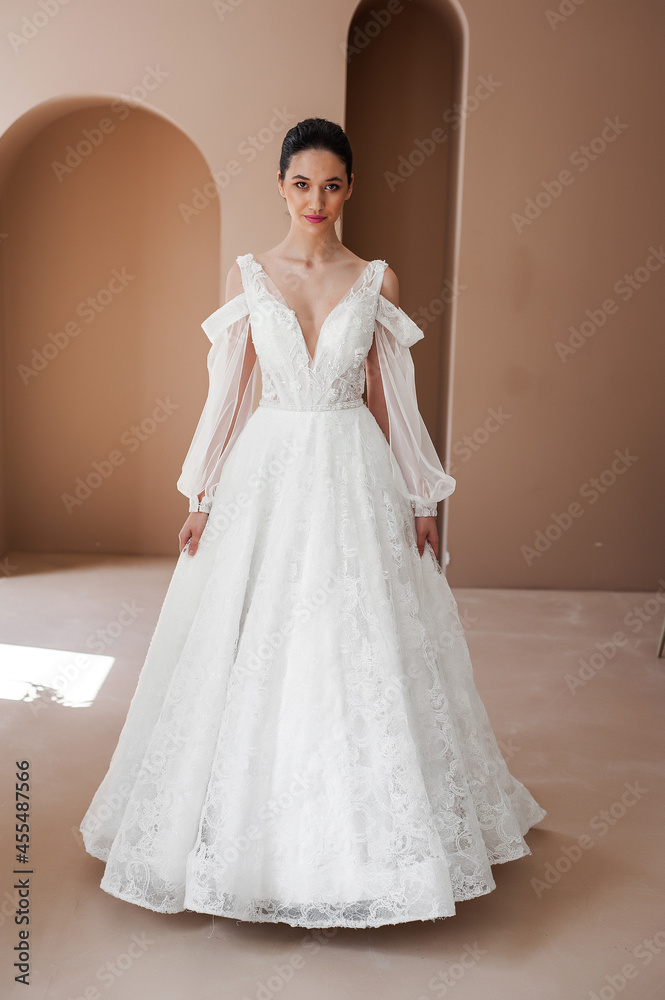Smiling young woman posing in a wedding dress Smiling young woman posing in a wedding dress
