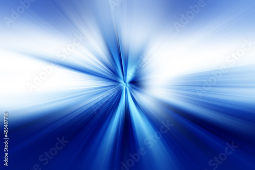 Abstract radial zoom blur surface in dark blue, light blue and white tones. Bright glowing blue background with radial, radiating, converging lines.