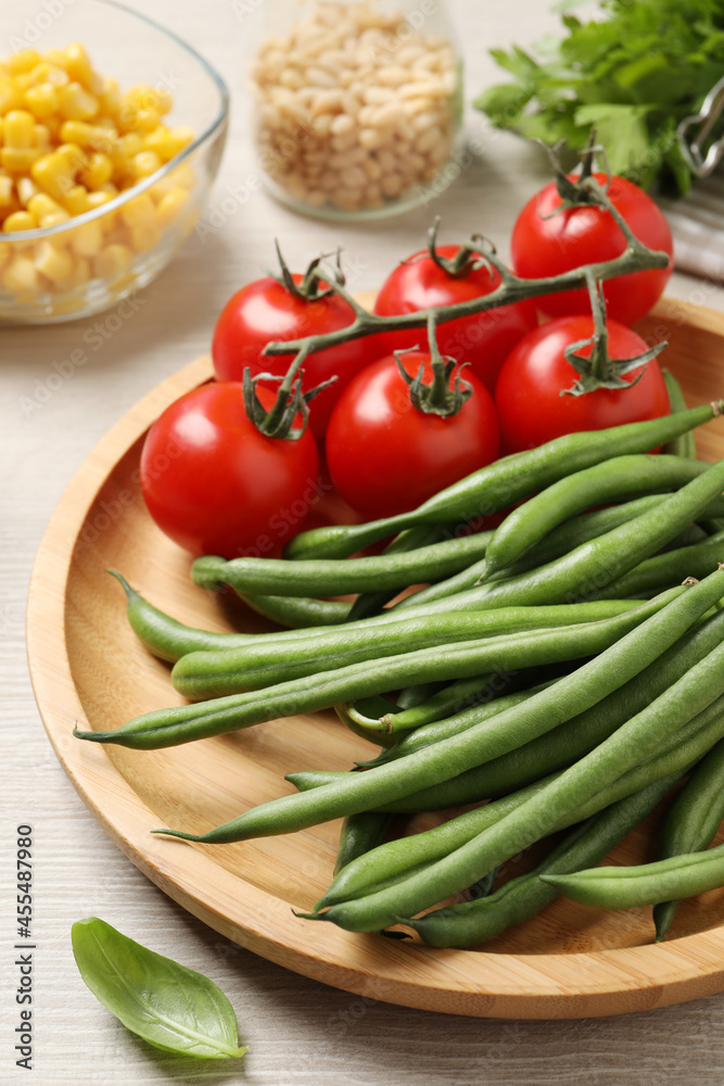 Fresh green beans and other ingredients for salad on white wooden table, closeup