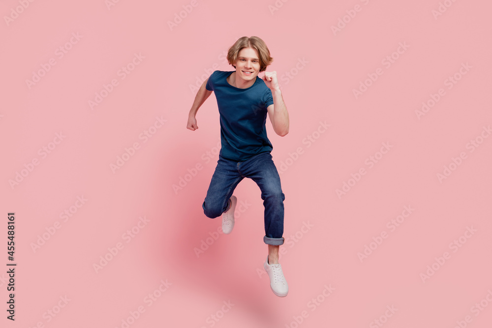 Portrait of funny athletic cheerful positive nice guy jump run look camera on pink background Portrait of funny athletic cheerful positive nice guy jump run look camera on pink background