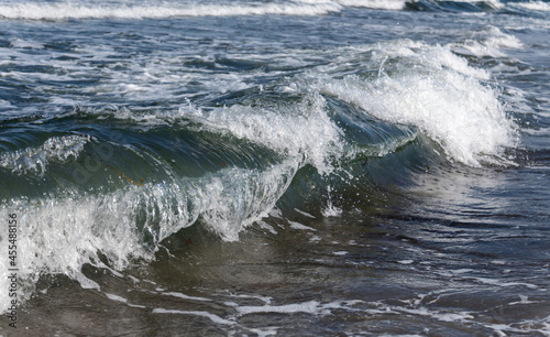 Wasserwellen mit weißer Gischt, brechen im flachen Wasser der Ostsee.