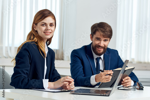 business man and woman work together in front of laptop professionals technology