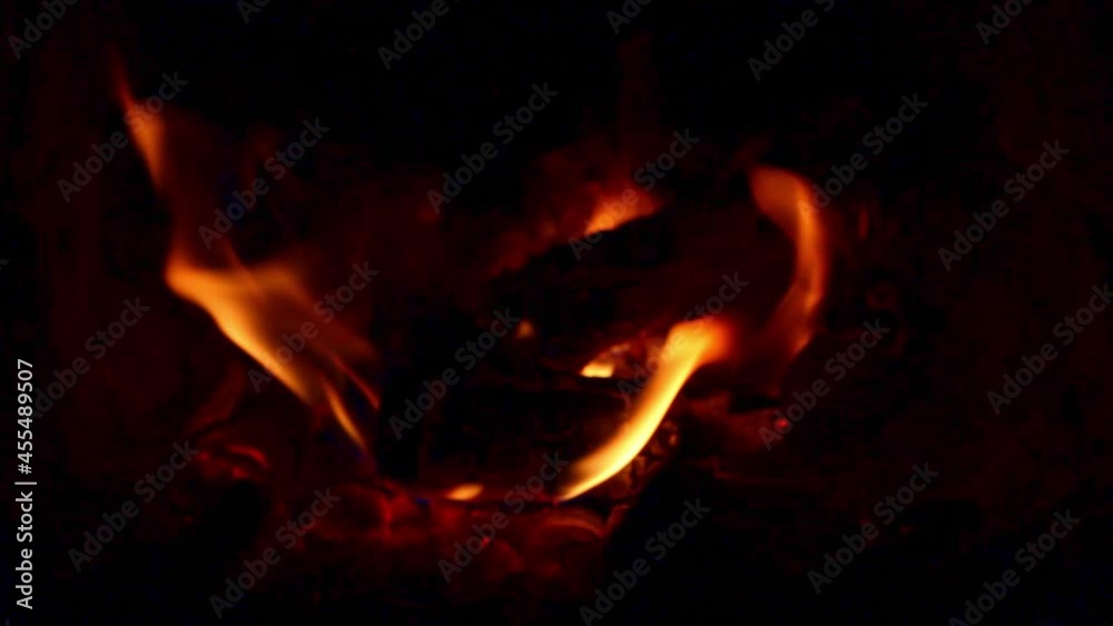 Small tongues of flame in the fireplace insert close-up, selective focus. Small tongues of flame in the fireplace insert close-up, selective focus.