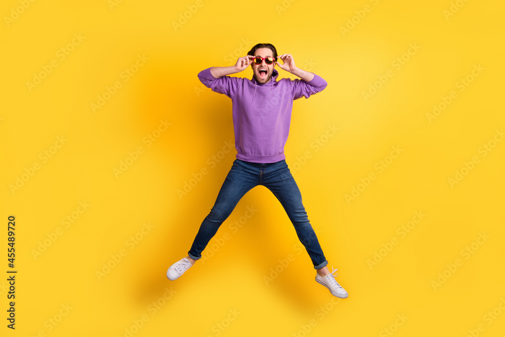 Full length photo of young excited man happy positive smile jump up isolated over yellow color background