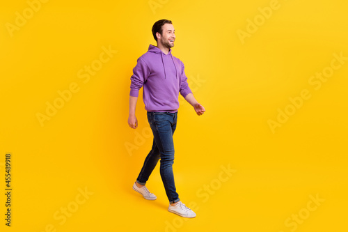 Full body profile side photo of young handsome man happy positive smile go walk isolated over yellow color background