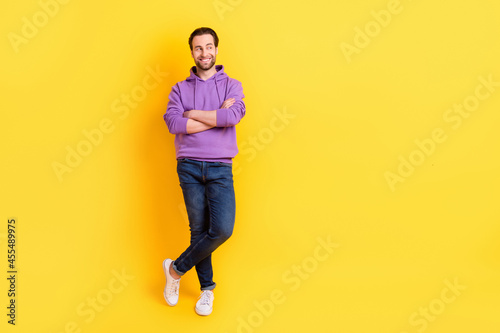 Full size photo of young handsome man happy positive smile crossed hands isolated over yellow color background