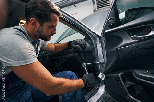 Foto Auto mechanic loosening nuts with ratcheting socket