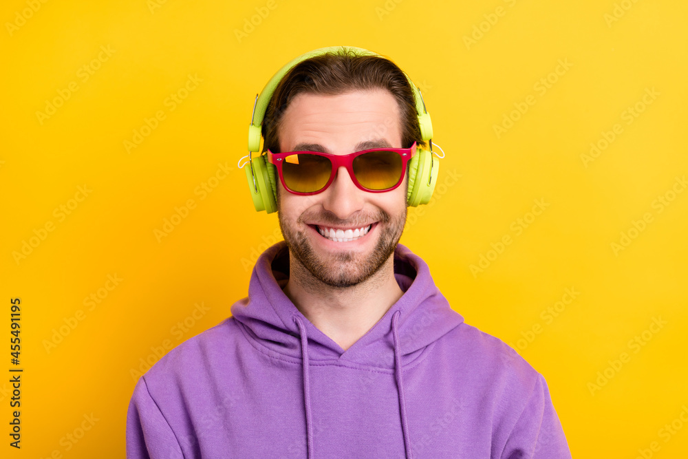 Photo of young man happy positive smile hipster wear sunglass listen music isolated over yellow color background Photo of young man happy positive smile hipster wear sunglass listen music isolated over yellow color background