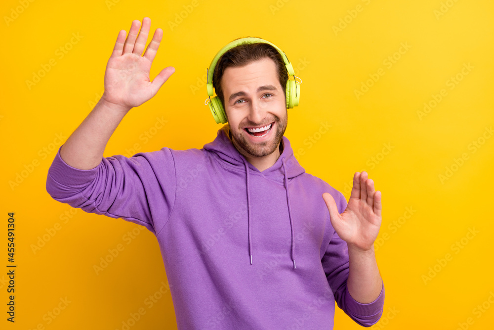 Photo of young man happy positive smile have fun dance party listen music earphones isolated over yellow color background Photo of young man happy positive smile have fun dance party listen music earphones isolated over yellow color background