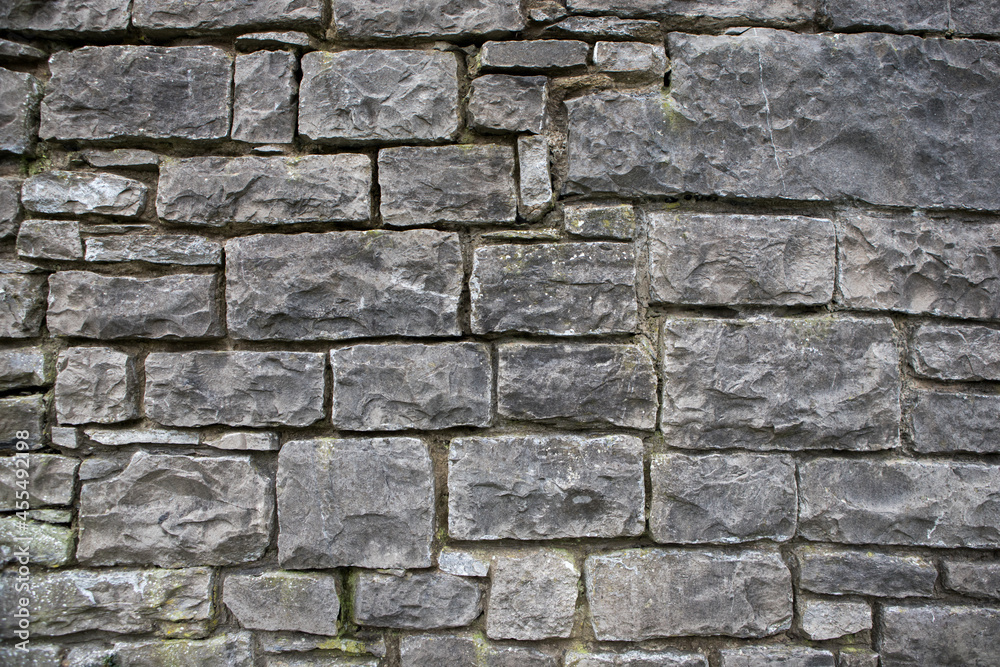 Textured stone wall background. Square patterns on an old grey wall Textured stone wall background. Square patterns on an old grey wall
